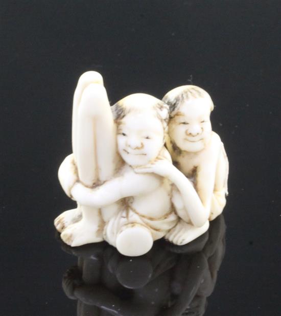 A Japanese ivory netsuke of seated Ashinaga and Tenaga, Meiji period, 3.7cm, repair to one foot